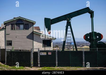 Puits d'huile et citrouilles dans la ville de signal Hill. Autrefois une zone de production massive de pétrole, les puits de pétrole sont encore mélangés dans ses quartiers résidentiels. Banque D'Images