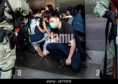 La police arrête les passants dans la rue après que les manifestants bloquent le quartier central, le principal quartier financier de Hong Kong après que la police a abattu un enfant le 11 novembre 2019. Banque D'Images