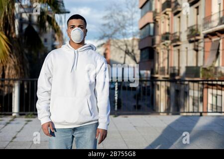 Homme malade portant un masque facial de protection contre les maladies infectieuses transmissibles et comme protection contre le coronavirus dans la place publique. Banque D'Images