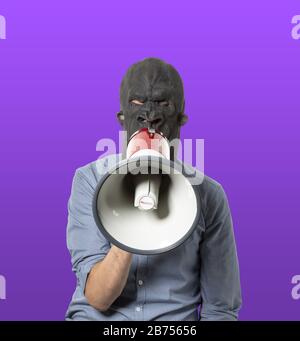Homme dans un masque noir en colère parlant sur un mégaphone Banque D'Images