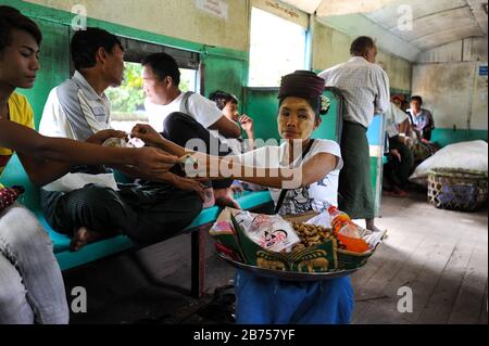 02.09.2013, Yangon, République de l'Union du Myanmar, Asie - une femme vend des arachides dans un compartiment ferroviaire de la Ringway. Son visage est osé avec la pâte typique de Thanaka. Le réseau ferroviaire de banlieue local dessert la région du Grand Yangon et est exploité par les chemins de fer du Myanmar. [traduction automatique] Banque D'Images