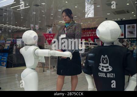 31.12.2017, Tokyo, Japon, Asie - une vendeuse a un contact visuel avec un robot semi-humanoïde de la série Pepper dans un magasin spécialisé du district de Shibuya. Le robot Pepper est fabriqué par SoftBank Robotics et a la capacité de reconnaître les émotions. [traduction automatique] Banque D'Images