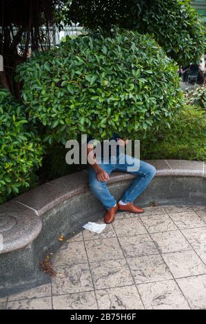 11.03.2018, Singapour, République de Singapour, Asie - un homme est assis sous un arbre dans le jardin du complexe People's Park dans le quartier chinois de Singapour. [traduction automatique] Banque D'Images