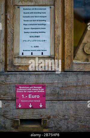 Des clichés bavarois et du kitsch alpin dans les boutiques touristiques le long de la Seestraße à Schönau am Königssee. Pour un euro, cette machine éjecte des panneaux en bois avec des timbres de marque. [traduction automatique] Banque D'Images