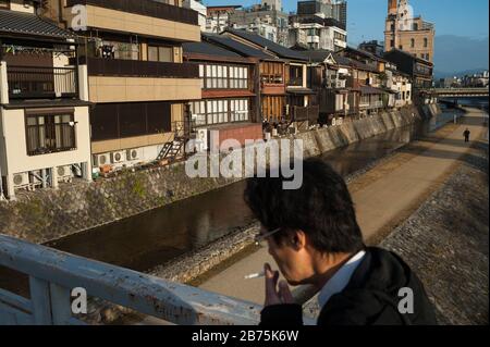 26.12.2017, Kyoto, Japon, Asie - un homme traverse un pont au-dessus du fleuve Kamo à Kyoto tôt le matin. [traduction automatique] Banque D'Images