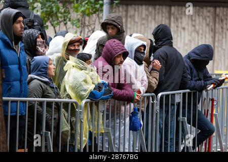 Les réfugiés demandeurs d'asile attendront leur inscription par temps froid et humide le 15 octobre 2015 au Bureau d'État de la santé et des affaires sociales de Berlin, LaGeSo. Avec des couvertures et des vêtements de pluie simples, les réfugiés essaient de se protéger de la pluie et du froid. [traduction automatique] Banque D'Images