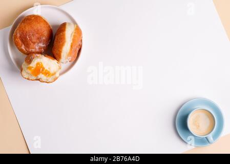 Tasse de café aromatique et délicieux sucre beignet maison fraîchement cuit glacé sur une plaque de céramique blanche sur un fond gris clair, espace de copie. Haut Banque D'Images