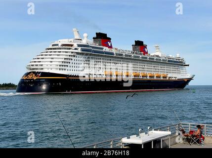 Port Canaveral, États-Unis. 13 mars 2020. 13 mars 2020 - Port Canaveral, Floride, États-Unis - un pêcheur regarde comme le bateau de croisière Disney Dream quitte Port Canaveral en Floride le 13 mars 2020. La ligne de croisière a suspendu les opérations de tous les nouveaux départs à compter du 14 mars en réponse à l'éclosion de coronavirus (COVID-19). Crédit: Paul Hennessy/Alay Live News Banque D'Images