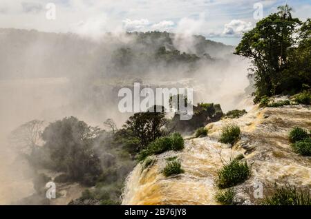 Une chute d'eau vue d'en haut, une partie des chutes d'Iguazu avec la nature environnante en Argentine avec une vue sur les arbres et la rivière avec brouillard d'eau Banque D'Images