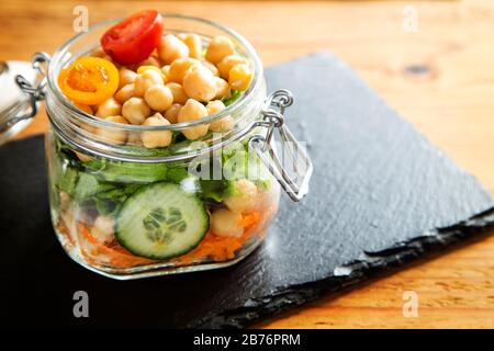 Pois chiches avec salade servis dans un pot en verre Banque D'Images