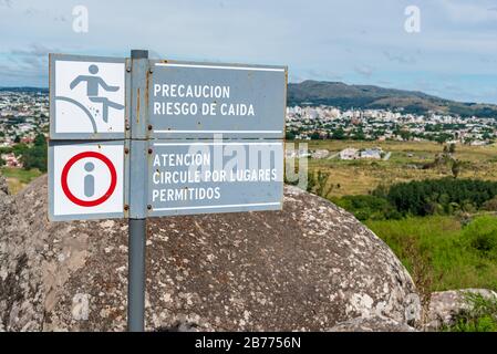 Signes d'avertissement de chute en espagnol signifiant "risque de précaution de chute" et "l'attention circule à travers les lieux autorisés", avec un paysage d'une ville dans Banque D'Images