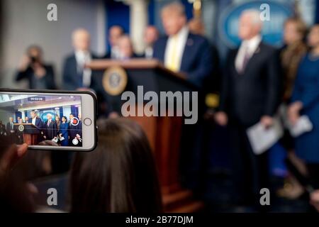 Washington, États-Unis D'Amérique. 9 mars 2020. Le président Donald J. Trump est vu sur un écran de téléphone portable lorsqu'il prononce des remarques lors d'une réunion d'information du Groupe de travail sur le coronavirus de la Maison Blanche le lundi 9 mars 2020 dans la salle d'information de presse James S. Brady du Peuple de la Maison Blanche: Le président Donald Trump crédit: Groupe de presse sur les tempêtes/Alamy Live News Banque D'Images