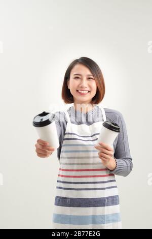 Un jeune barista sert du café dans des tasses jetables Banque D'Images