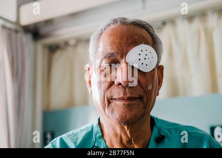 patient couvrant les yeux avec protection et plâtre médical après les yeux chirurgie de la cataracte à l'hôpital Banque D'Images