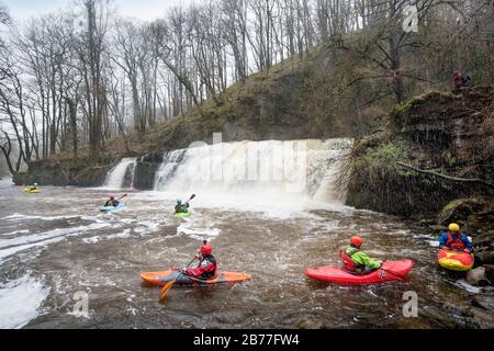 Les kayakistes se reposent dans la piscine de plongée après avoir fait du vélo le Sgwd y Pannwr tombe sur la rivière Mellte près de Pontnedfechan dans les Brecon Beacons, Pays de Galles Royaume-Uni Banque D'Images