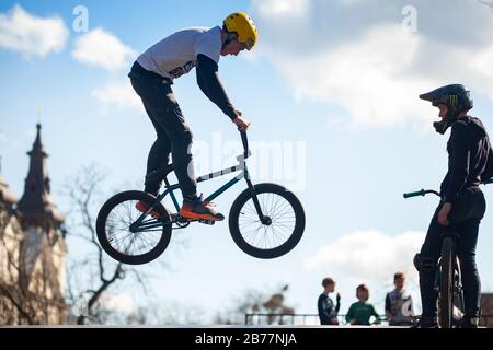 Lviv, Ukraine - 12 mars 2020: Jeune homme faisant des tours sur un vélo BMX. Vélos pour adolescents dans un parc de patinage et de vélo urbain Banque D'Images