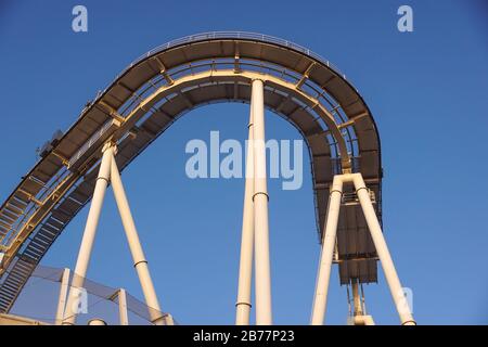 détail de la piste de montagnes russes incurvées au coucher du soleil Banque D'Images