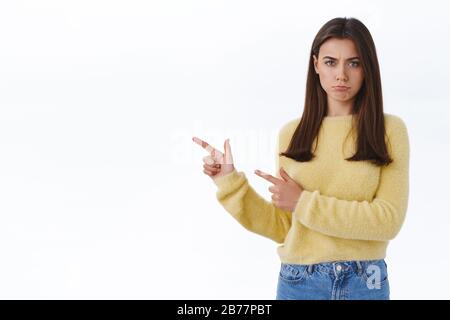 Le poupe jaloux a offensé la jolie petite amie sulocie dans le chandail jaune, frognant et regardant insulté comme doigt de pointage gauche, ne recevait pas quelque chose elle Banque D'Images