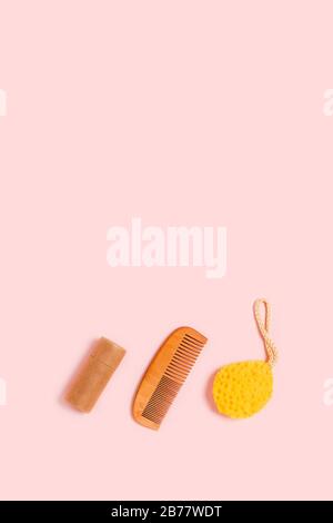 Accessoires écologiques pour bains de femme : éponge naturelle, peigne en bois et tube artisanal. Image verticale. Banque D'Images