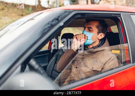 Homme malade assis en voiture portant un masque de protection toussant ayant un coronavirus de grippe. Interdiction de conduire l'automobile avec de la fièvre. Banque D'Images
