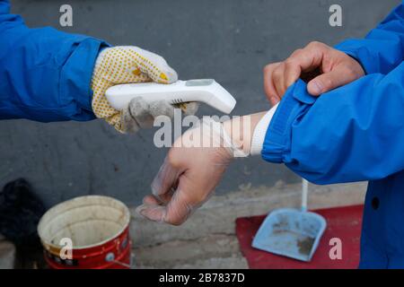 (200314) -- BEIJING, 14 mars 2020 (Xinhua) -- Li Jie a vérifié sa température corporelle avant de travailler à Beijing, capitale de la Chine, 12 mars 2020. Li Jie, un livreur de ZTO Express, travaille dans l'industrie de la livraison express depuis 11 ans. Au lieu de rentrer à la maison dans la nouvelle région de Xiong'an, dans la province de Hebei en Chine du nord, il a séjourné à Beijing et a travaillé pendant les dernières vacances du Festival du printemps. Après l'éclosion de la COVID-19, les gens préfèrent rester à la maison pour empêcher la propagation du coronavirus; pendant que les commandes en ligne augmentent et les livymen se font très occupés. En tant que membre de trois millions de livraison Banque D'Images