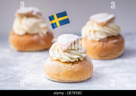 Semlor, fastelavnsbolle, fastlagsbulle. Petits pains traditionnels à base de cardamome crème scandinave avec pâte d'amandes. Décoré avec un drapeau suédois. Horizo Banque D'Images