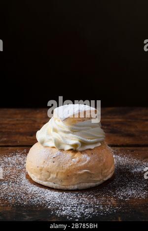 Petits pains Semlor, Fastelavnsbolle ou Fastlagsbulle, un pain scandinave traditionnel. Petits pains cardamome à la crème avec pâte d'amandes. Dans un style rétro vintage Banque D'Images