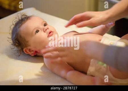 Massage de bébé. Massagiste massage à un petit bébé Banque D'Images