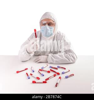 L'homme dans un costume de protection et un masque contient un tube de test sanguin d'échantillon Banque D'Images