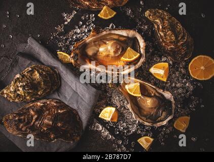 Huîtres fraîches sur glace écrasée avec citron. Nourriture saine, nourriture gastronomique, nourriture de restaurant. Vue de dessus. Banque D'Images