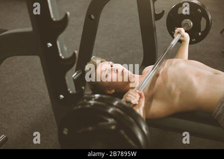 Sportif homme exécutant l'exercice d'haltérophilie à la salle de sport, s'exerçant avec barbell. Banque D'Images