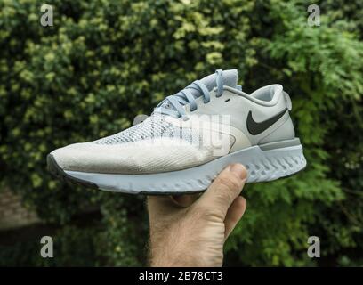 Paris, France - 23 sept. 2019 : homme POV montre la main sur fond vert chaussure de course professionnelle fabriquée par Nike modèle Zoom Rival Fly Banque D'Images