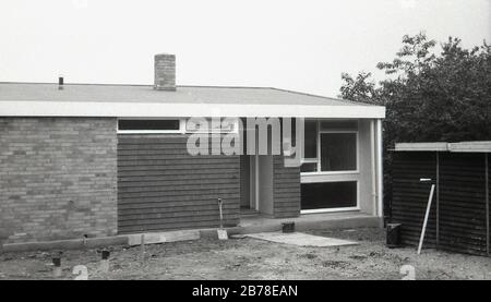 Fin des années 60, peut-être début des années 70, récemment construit, une nouvelle maison moderne d'un étage, un bungalow, avec un mélange de briques et de tuiles revêtues d'extérieur, montrant le style architectural et le design de ces bâtiments de bas niveau dans cette époque, qui a utilisé un certain nombre de conceptions de bâtiments mixtes et des panneaux de fenêtre pré-construits, Angleterre, Royaume-Uni. Banque D'Images