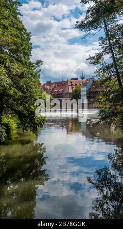 Nuremberg 2019. Pont Max au-dessus de la rivière Pegnitz vue entre les arbres et les rives. Nous sommes en été ensoleillé mais nuageux. Août 2019 à Nuremberg Banque D'Images