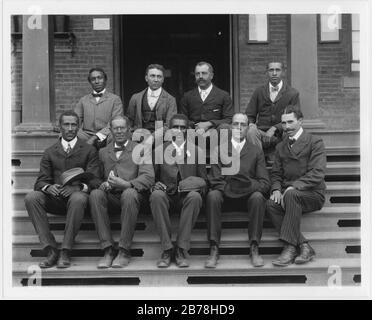 George Washington Carver, portrait sur toute la longueur, assis sur les marches, face à l'avant, avec le personnel Banque D'Images