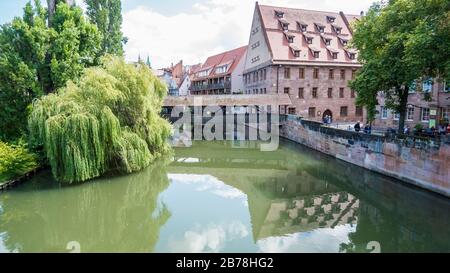 Nuremberg 2019. Les gens traversant le pont du Hangman au-dessus de la rivière Pegnitz. Nous sommes sur une journée d'été chaude et nuageux. Août 2019 à Nuremberg Banque D'Images