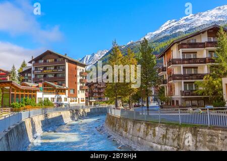Zermatt, Suisse - 7 octobre 2019: Vue sur la rue de la ville dans la célèbre station de ski des Alpes suisses, rivière, montagne de neige Banque D'Images
