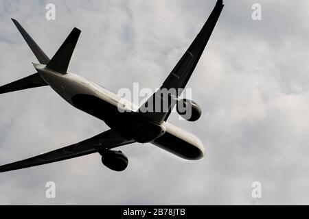 Gros plan de l'avion-jet qui s'envolent dans le ciel nuageux. Vue de dessous d'un grand avion en silhouette. Mise en place d'un coup de déplacement. Aéroplas modernes Banque D'Images