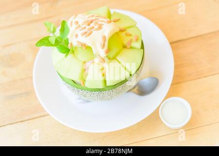 Melon Bingsu avec Lait condensé Sucré sur table en bois Banque D'Images