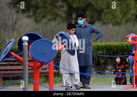 (200314) -- ISLAMABAD, le 14 mars 2020 (Xinhua) -- un homme portant un masque facial est vu dans un parc public à Islamabad, capitale du Pakistan, le 14 mars 2020. Le gouvernement du Pakistan a annoncé de mettre à niveau ses mesures contre COVID-19 dans tout le pays après que 28 personnes ont testé le virus positif au cours des 17 derniers jours, a déclaré l'adjoint spécial au Premier ministre de la Santé Zafar Mirza aux médias ici vendredi soir. Le pays a interdit toutes sortes de rassemblements publics, y compris les festivals sportifs et culturels, les rassemblements récréatifs dans les cinémas et les théâtres, les cérémonies de mariage dans les salles ou les salles ouvertes Banque D'Images