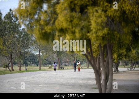 (200314) -- ISLAMABAD, 14 mars 2020 (Xinhua) -- quelques personnes marchent dans un parc public à Islamabad, capitale du Pakistan, 14 mars 2020. Le gouvernement du Pakistan a annoncé de mettre à niveau ses mesures contre COVID-19 dans tout le pays après que 28 personnes ont testé le virus positif au cours des 17 derniers jours, a déclaré l'adjoint spécial au Premier ministre de la Santé Zafar Mirza aux médias ici vendredi soir. Le pays a interdit toutes sortes de rassemblements publics, y compris les festivals sportifs et culturels, les rassemblements récréatifs dans les cinémas et les théâtres, les cérémonies de mariage dans les salles ou les lieux ouverts, les réunions Banque D'Images