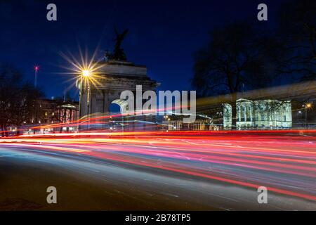 Wellington Arch et Apsley House, Hyde Park Corner, Londres, Angleterre, Royaume-Uni à l'heure de pointe avec des sentiers de signalisation routière Banque D'Images