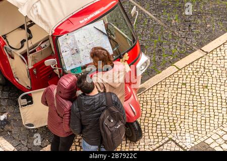 Lisbonne, Portugal - 3 mars 2020: Guide touristique et touristes regardant la carte de Lisbonne sur le pare-brise Tuk Tuk Banque D'Images