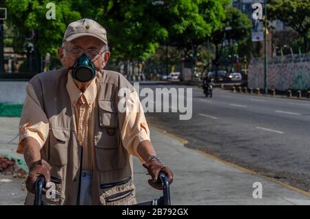 Caracas, Miranda, Venezuela. 14 mars 2020. Un homme plus âgé porte un masque en cuir et des gants pour se protéger. Le coronavirus est arrivé au Venezuela. Cela a été confirmé par le vice-président du pays le vendredi 13 mars. Deux citoyens vénézuéliens de l'État de Miranda à Caracas sont les premiers cas confirmés de coronavirus dans le pays. Crédit: Jimmy Villalta/Zuma Wire/Alay Live News Banque D'Images