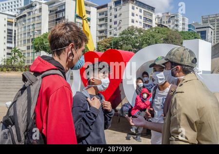 Caracas, Miranda, Venezuela. 14 mars 2020. Les jeunes parlent à la Plaza Francia à Altamira avant d'aller à leur travail de restauration rapide. Le coronavirus est arrivé au Venezuela. Cela a été confirmé par le vice-président du pays le vendredi 13 mars. Deux citoyens vénézuéliens de l'État de Miranda à Caracas sont les premiers cas confirmés de coronavirus dans le pays. Crédit: Jimmy Villalta/Zuma Wire/Alay Live News Banque D'Images