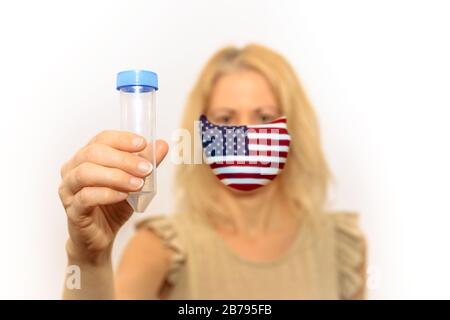 Femme avec masque de pavillon américain tenant un tube à essai. Concept de l'éclosion et de la quarantaine pour l'infection du coronavirus aux États-Unis Banque D'Images