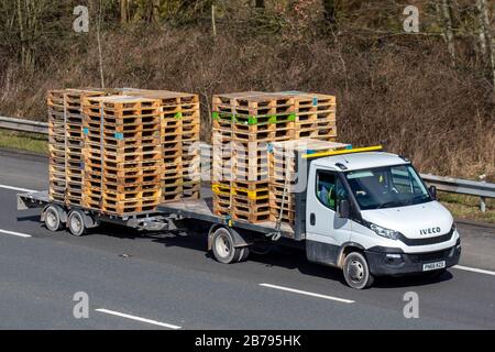 Palettes en bois sur une fourgonnette et une remorque Iveco à lit plat ; industrie du transport, M61 à Manchester, Royaume-Uni Banque D'Images