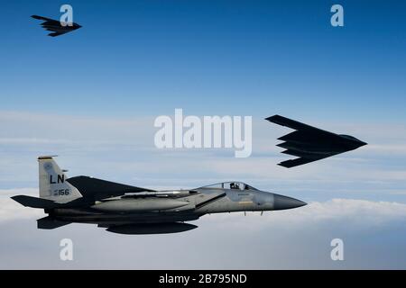 Les bombardiers stratégiques furtifs B-2 Spirit de l'armée de l'air américaine volent en formation avec un avion de chasse F-15 C Eagle pendant les opérations à l'appui de la Force opérationnelle de bombardement Europe 20-2 le 12 mars 2020 au-dessus de la mer du Nord au large de la côte de l'Écosse. Banque D'Images