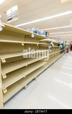 Vider les étagères dans un supermarché épicerie dans l'eau embouteillée isle comme coronavirus provoque la peur et la panique horizontale Banque D'Images