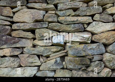 Mur en pierre rustique clôture texture background dans l'arrière-cour à l'extérieur. Banque D'Images